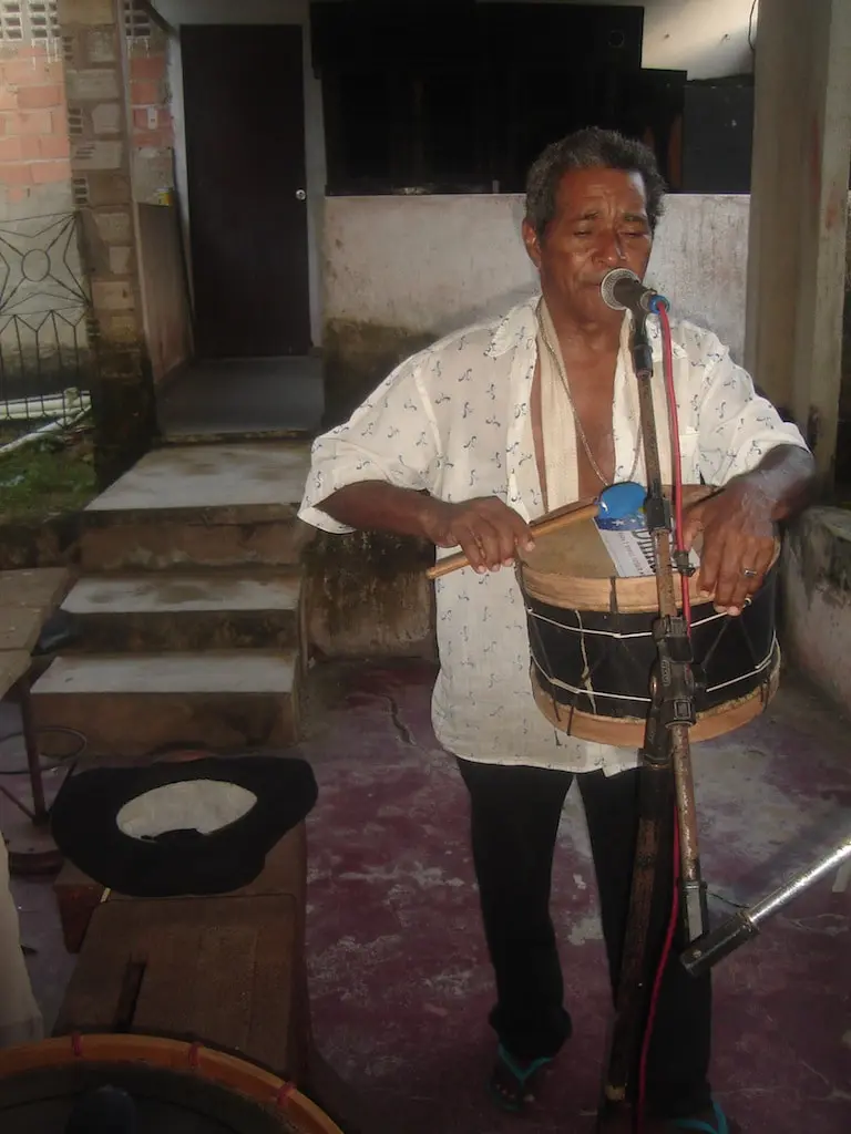 Mestre Faustino, de Ourém, tocando percussão e cantando ao microfone. Ourém, 14/09/2010.